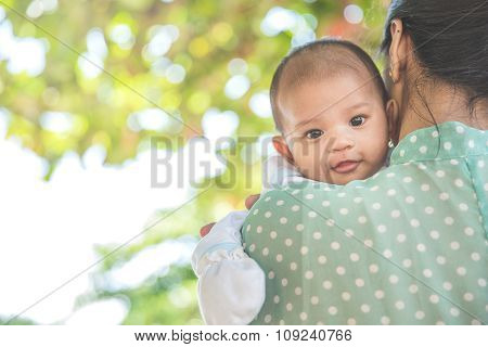 Woman Holding Her Baby Daughter, Baby Looing At The Camera