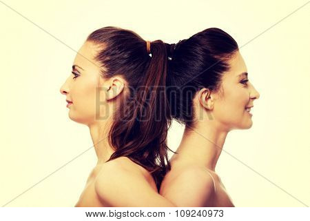 Two attractive topless sisters with make up.