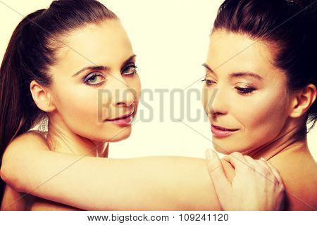 Two attractive sisters with make up embracing.