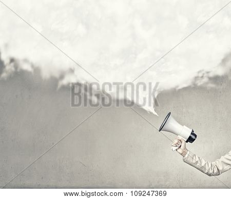 Hand holding megaphone and white speech blank cloud 
