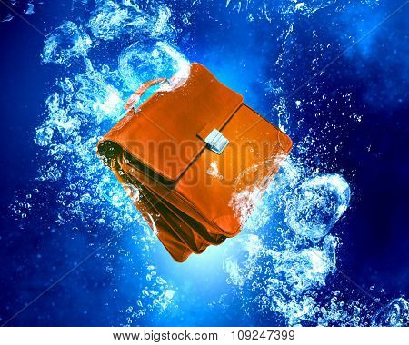 Unemployment concept with biefcase sink in clear blue water