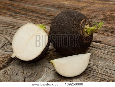 Black radish on wooden background