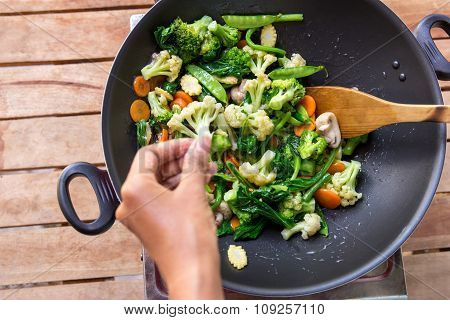 Human Hands Spreading Salt Into Chinese Food Capcay