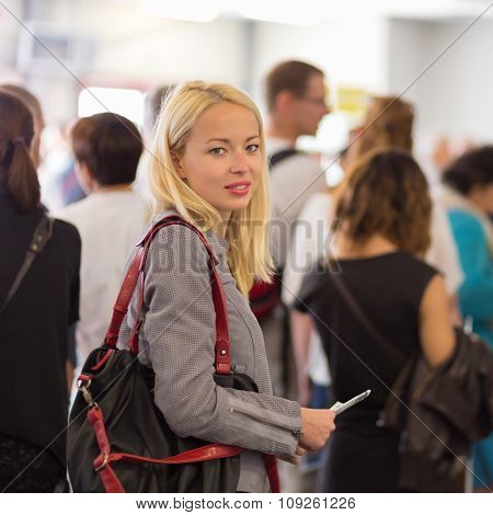 Young blond caucsian woman waiting in line.