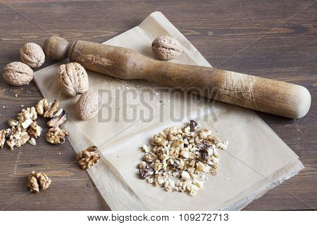 Walnuts in paper and wood battledore on a wooden background