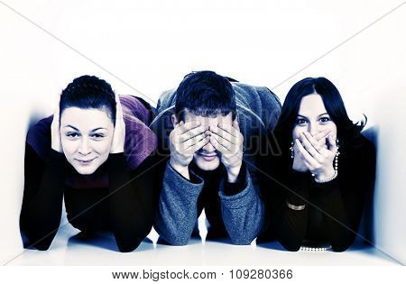 Three young people in small space covering ears, mouth and eyes. communication concept