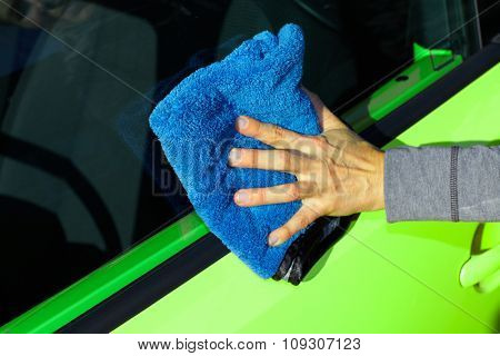 Hand with cloth washing a car. Waxing and polishing.