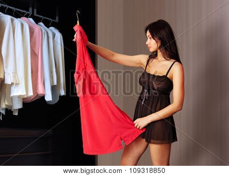 beautiful woman fits on a red dress in the shopping mall