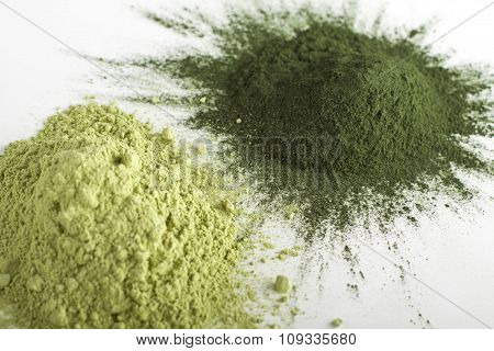 Spirulina and barley grass raw powder on white background - heap.