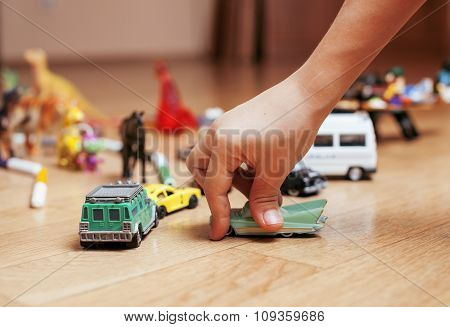 children playing toys on floor at home, little hand in mess