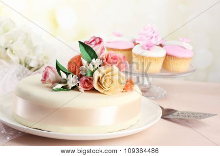 Cake with sugar paste flowers, on light background