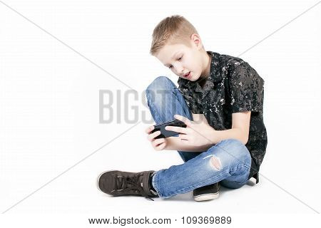 Teenager boy searching something on a smart phone isolated.