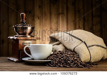 still life with coffee beans and old coffee mill on the wooden background 