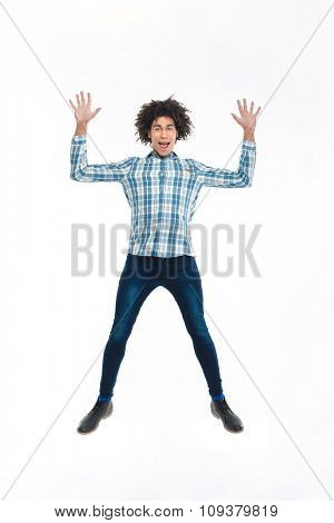 Full length portrait of a funny afro american man jumping isolated on a white background