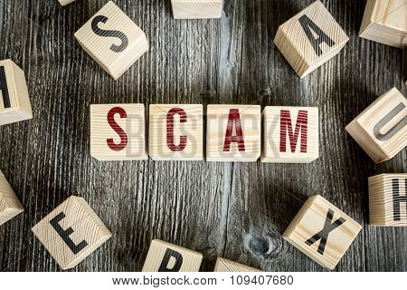 Wooden Blocks with the text: Scam