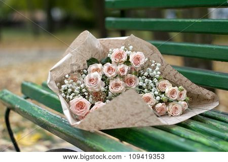 Beautiful bouquet in the paper on the bench