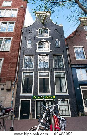 AMSTERDAMNETHERLANDS-APRIL 27: Tipical Amsterdam architecture and appartments with bike in foreground on April 27 2015 in Amsterdam Netherlands.