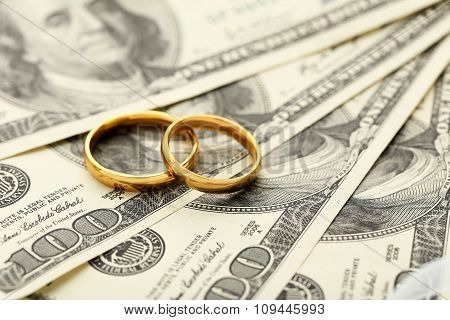 Golden Wedding Rings On One Hundred Dollars Bill Background