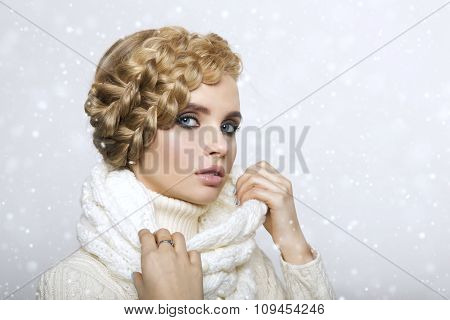 portrait of a beautiful young blonde woman on a light background. hair tied in a braid. girl wearing