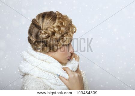 portrait of a beautiful young blonde woman on a light background. hair tied in a braid. girl wearing