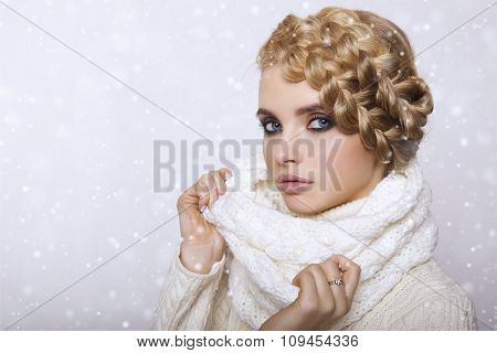 portrait of a beautiful young blonde woman on a light background. hair tied in a braid. girl wearing