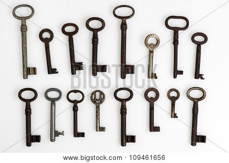collection of old rusty keys on white
