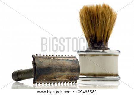 old shaving kit - razor and a shaving brush - on white