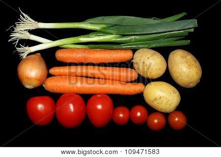 Tomatoes,onions,carrots,potatoes on a black background