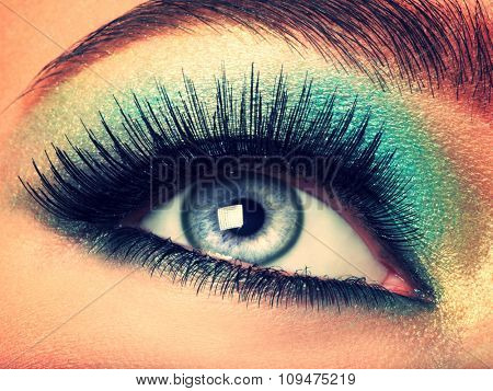 Woman's eye with green eye make-up. Long eyelashes