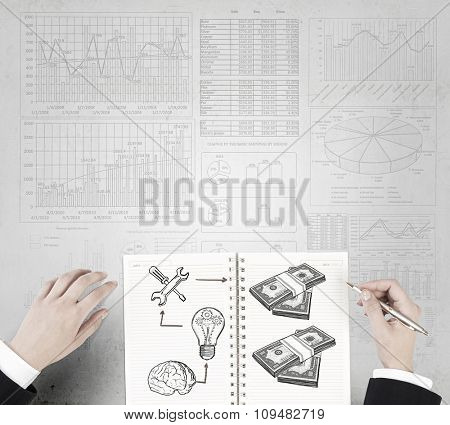 Businessman hands drawing money making formula in notepad