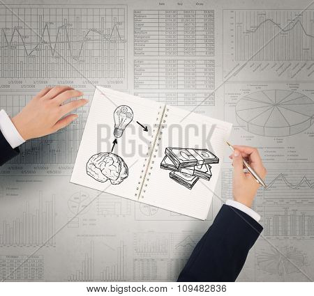 Businessman hands drawing money making formula in notepad