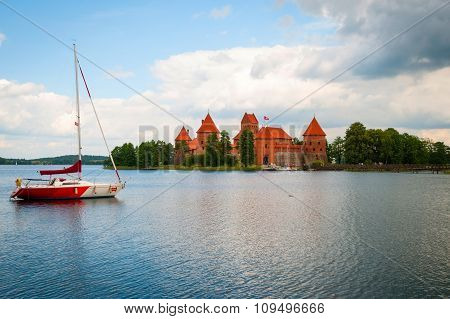 TRAKAI, LITHUANIA - JULY 20: Trakai castle by the lake with sailing boat in front. July 2015