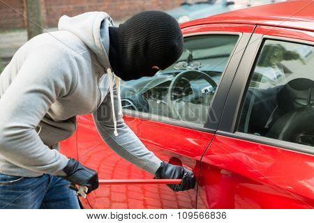 Thief With Mask Using Crowbar To Open Car's Door