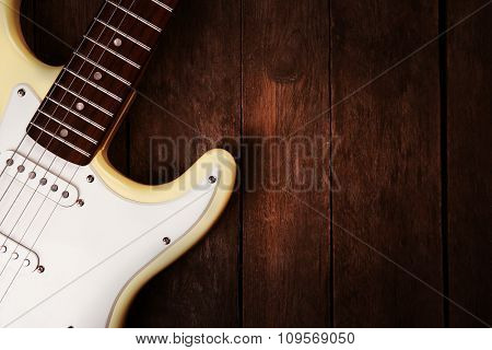Electric guitar on wooden background, close up