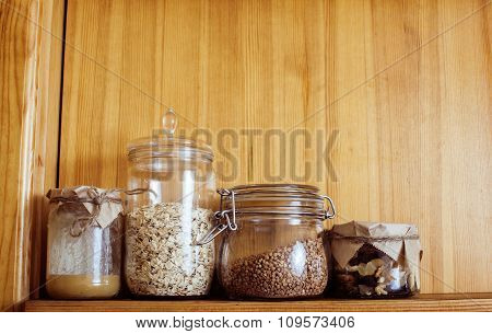 real comfort wooden kitchen with breakfast ingredients close up in glass, honey, oatmeal, milk, mues