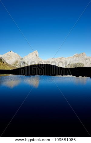 Peaks reflected in Ansabere Lake. Lescun Cirque. Aspe Valley, Pyrenees, France.