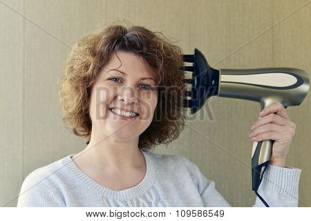 Woman doing curls with  hairdryer and diffuser