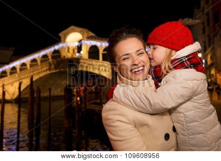Daughter Kissing Mother Near Rialto Bridge In Christmas Venice