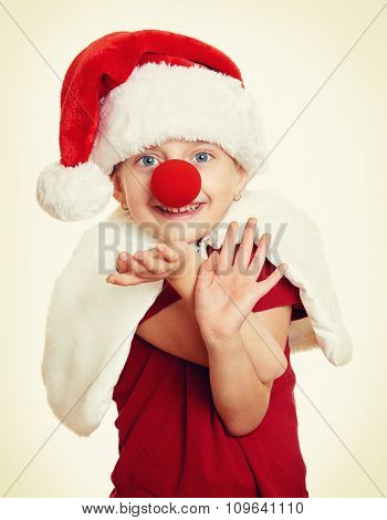 girl in santa hat with clown nose on white isolated