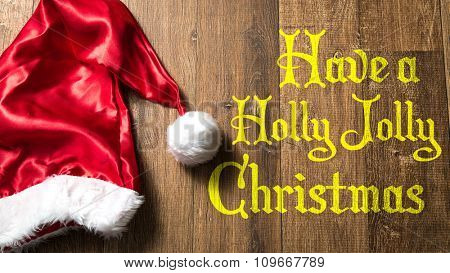 Have a Holly Jolly Christmas written on wooden with Santa Hat
