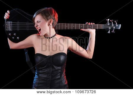 Sexy girl in leather clothes with bass guitar. punk rocker