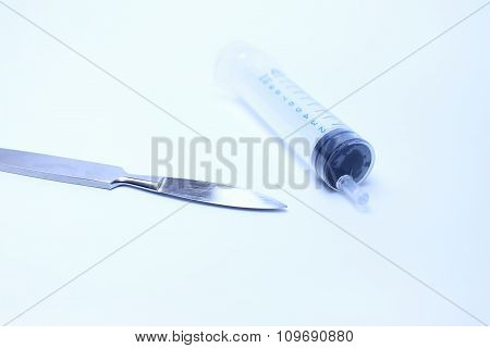 Syringe and a scalpel
