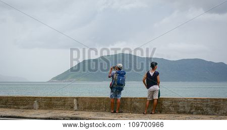 Young Men Standing And Seeing The Sea