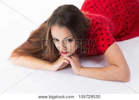 Young and beautiful girl with long straight hair is dreaming, lying isolated on white background