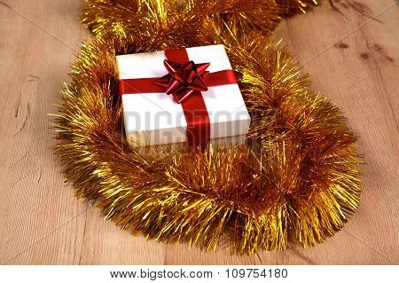 New Year gift on a golden tinsel background boly