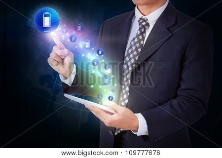 Businessman holding tablet with pressing battery charge icon button. internet and networking concept