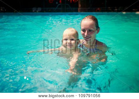 Closeup Mother Small Daughter Swim Smile In Azure Water Of Pool