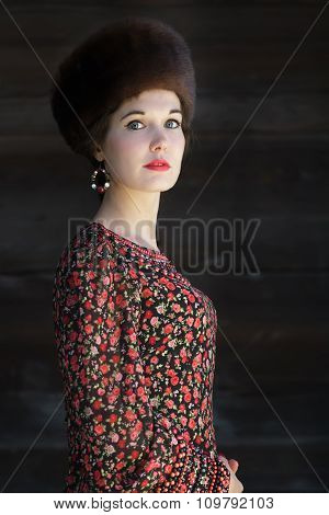 Three-quarter view portrait of young woman in Russian style fashion costume with fur Cossack hat