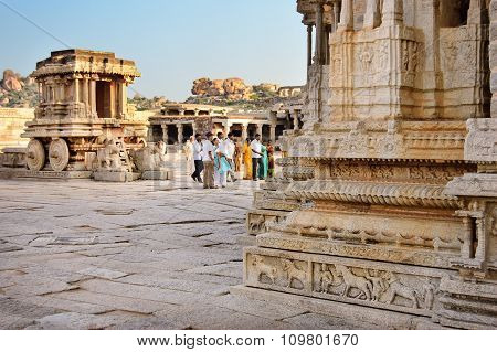 Hampi India - 19 November 2014: People walking in front of stone chariot in courtyard of Vittala Temple in Hampi Karnataka India.