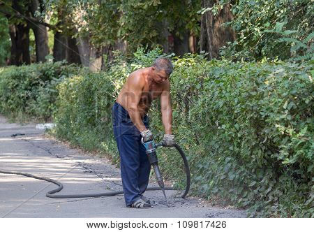 Kiev, Ukraine - September 01, 2015: Worker Using A Jackhammer To Remove The Asphalt Road Repair